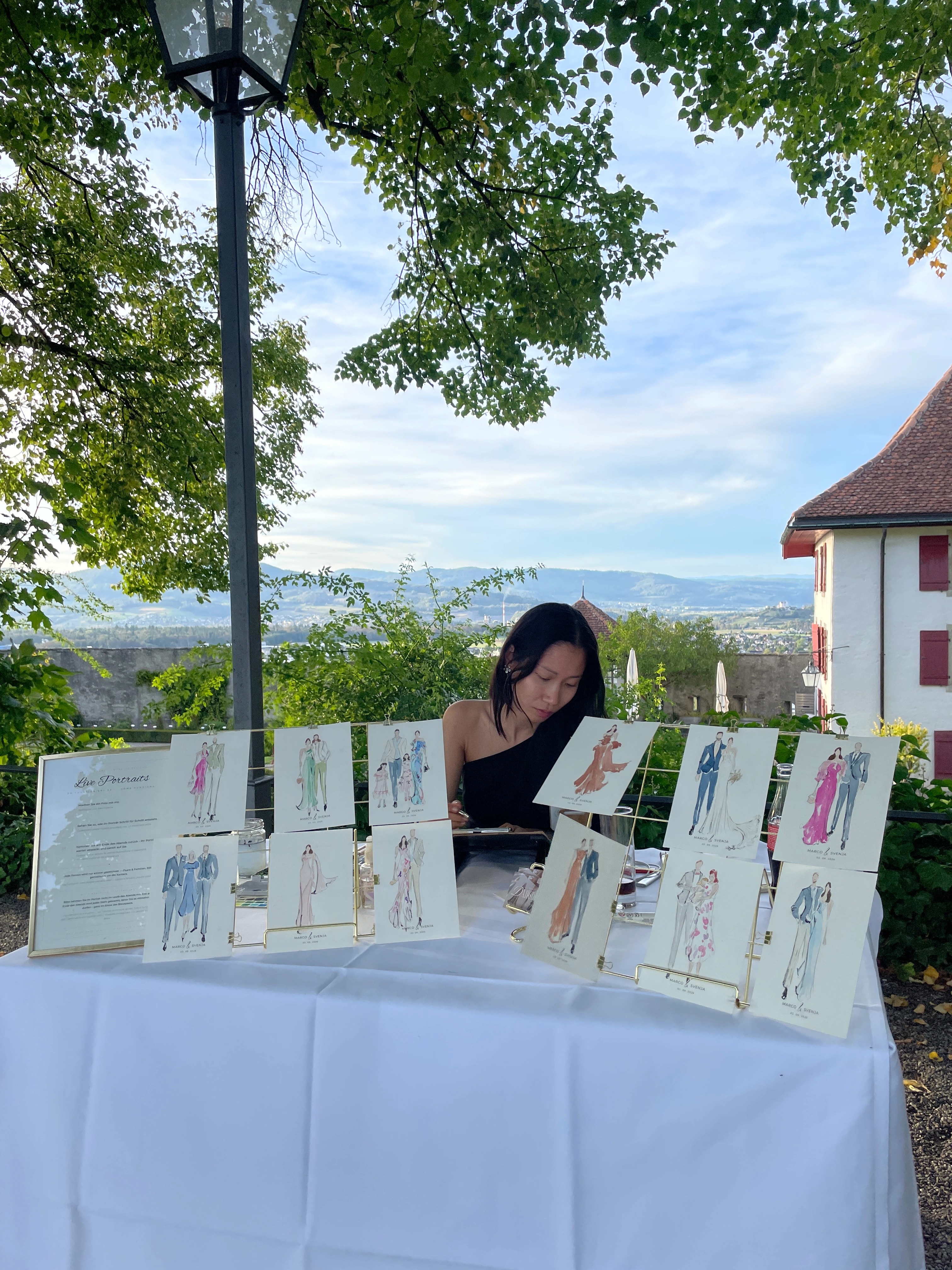 Painting station with a row of finished watercolor guest portraits on the terrace of Schloss Lenzburg