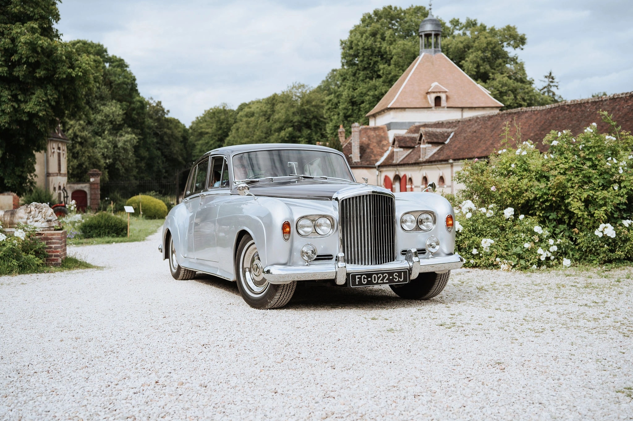 Ein Oldtimer-Hochzeitsauto kommt am Eingang des historischen Château du Feÿ im Burgund an.