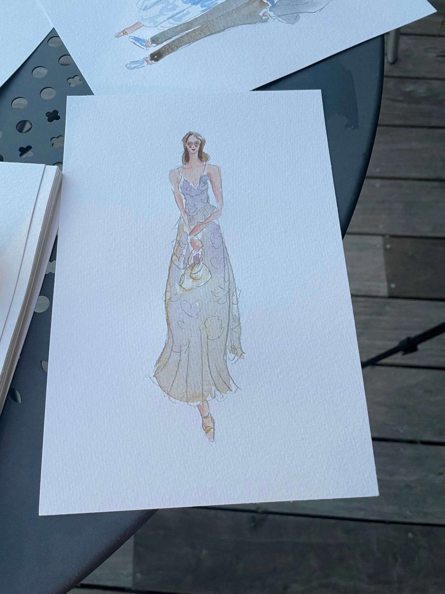 Live gemaltes Aquarell-Porträt eines Gasts im violetten Blumenkleid mit Handtasche.