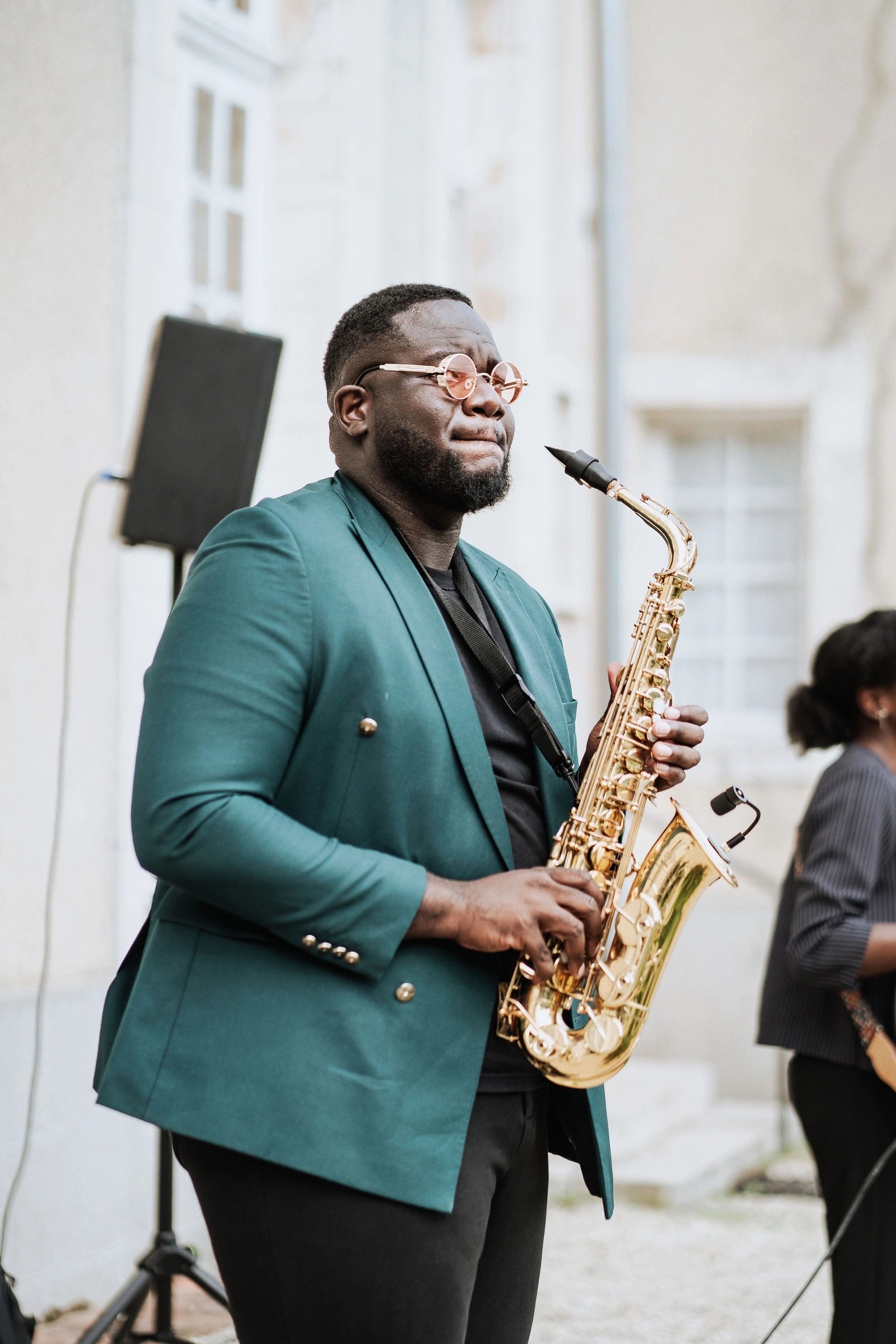 Ein Saxophonist spielt live während des Hochzeits-Cocktails im Freien im Château du Feÿ. Foto: Kimmak Design.