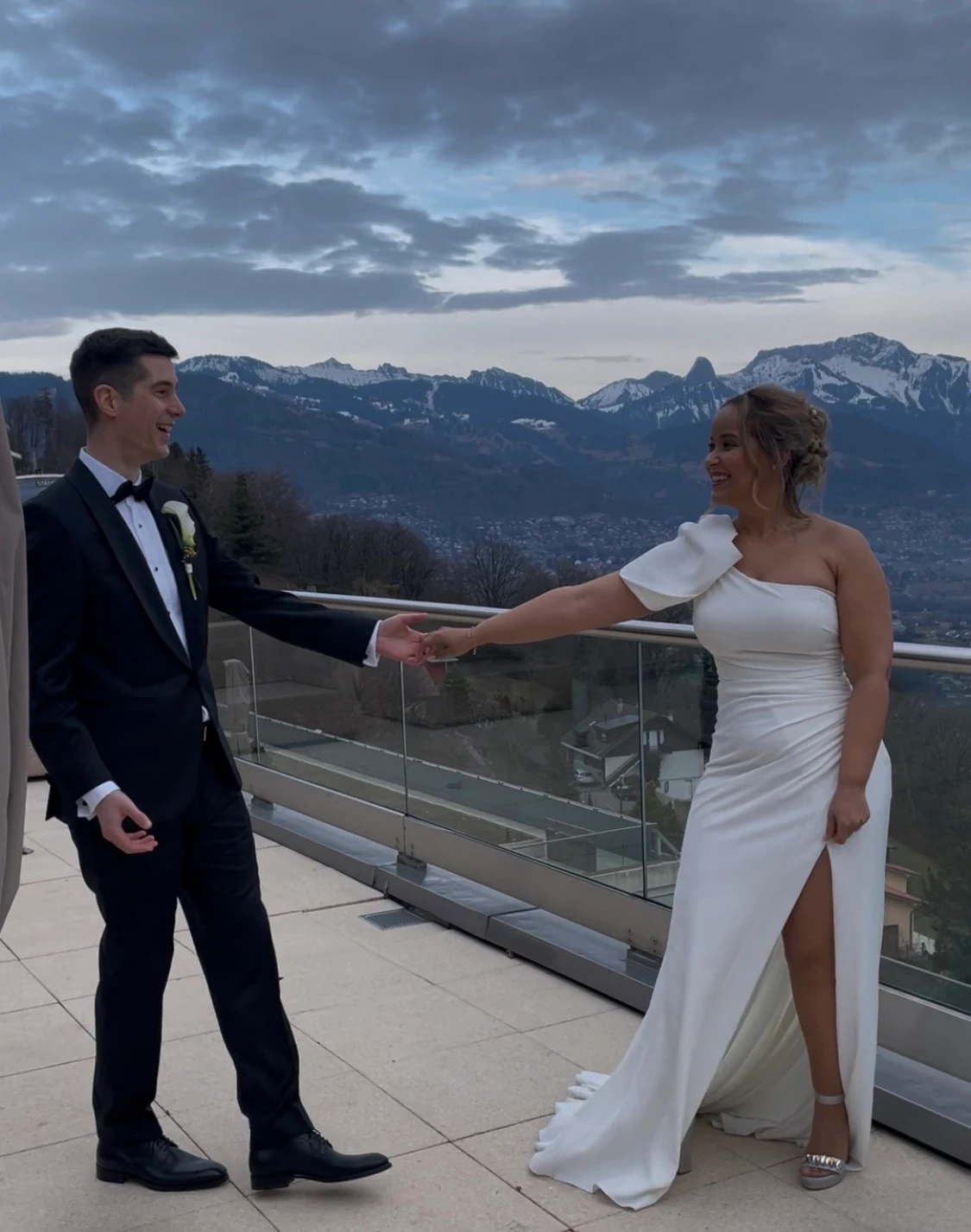 Bride and groom in a dance pose on the terrace of Le Mirador with the Alps behind them, reference photo for the live wedding painting