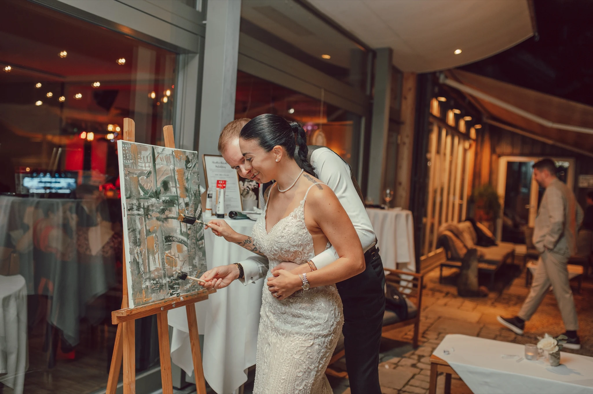Bride and groom painting the abstract guest canvas together at their wedding at Moschti Stäfa. Photography by Geraldine Rhyner Fotografie.