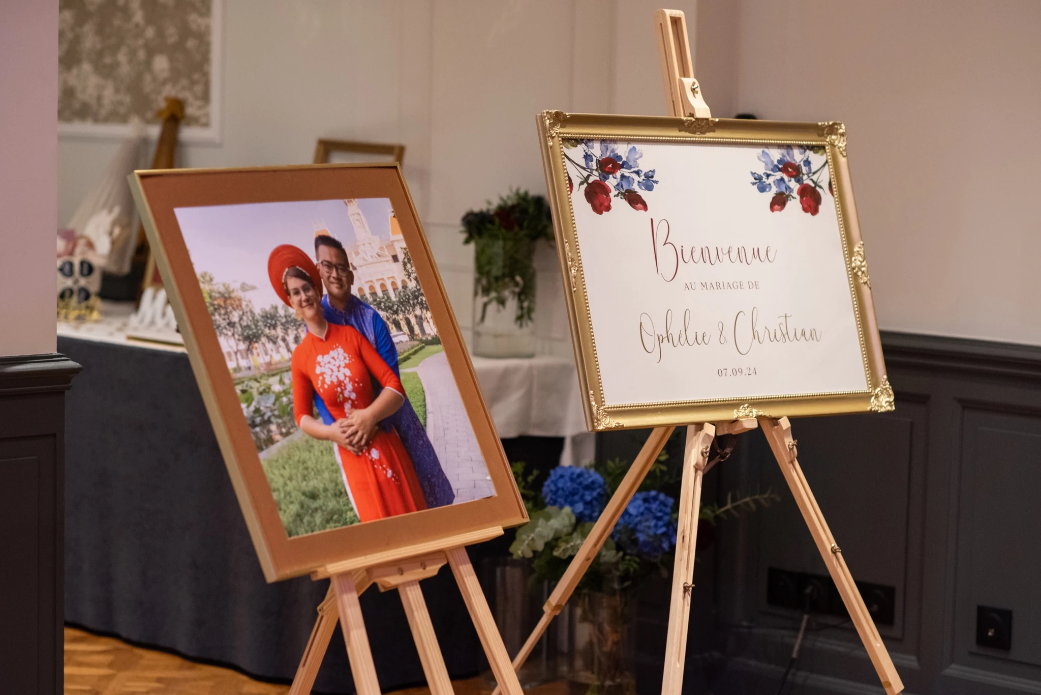 Portrait of the couple in traditional Vietnamese ao dai on an easel next to the wedding welcome sign at Château de la Tour. Photography by GC Photographie.