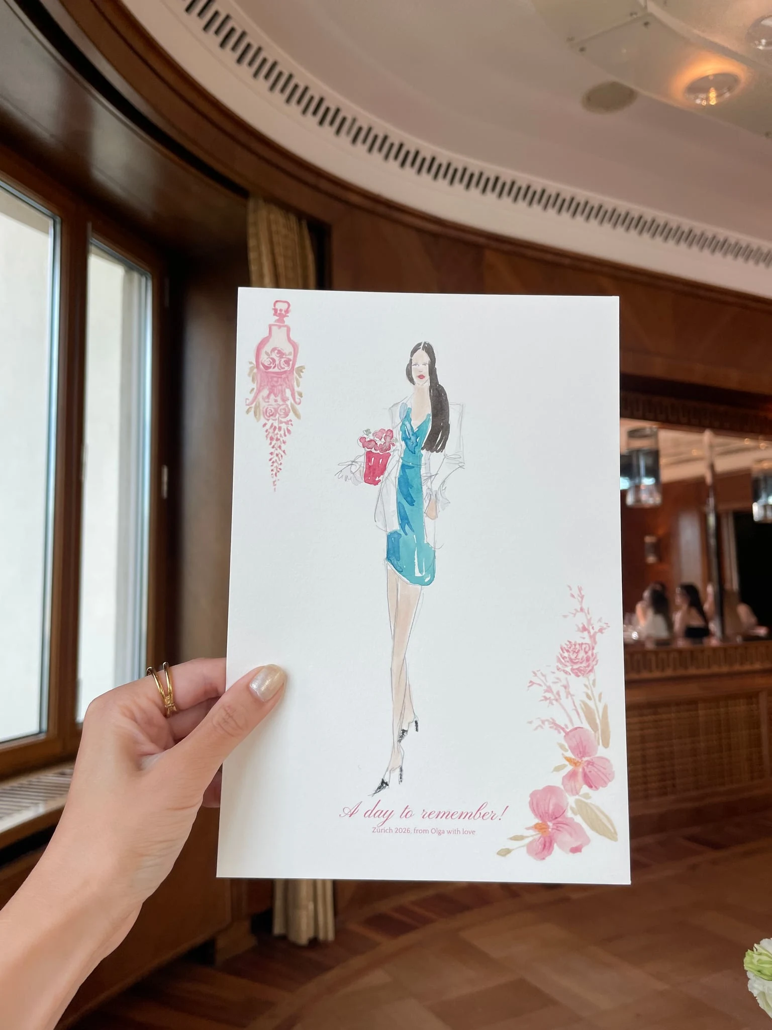 Live watercolor illustration of a guest in a turquoise dress with a red handbag at a birthday party at AMERON Zürich Bellerive au Lac.