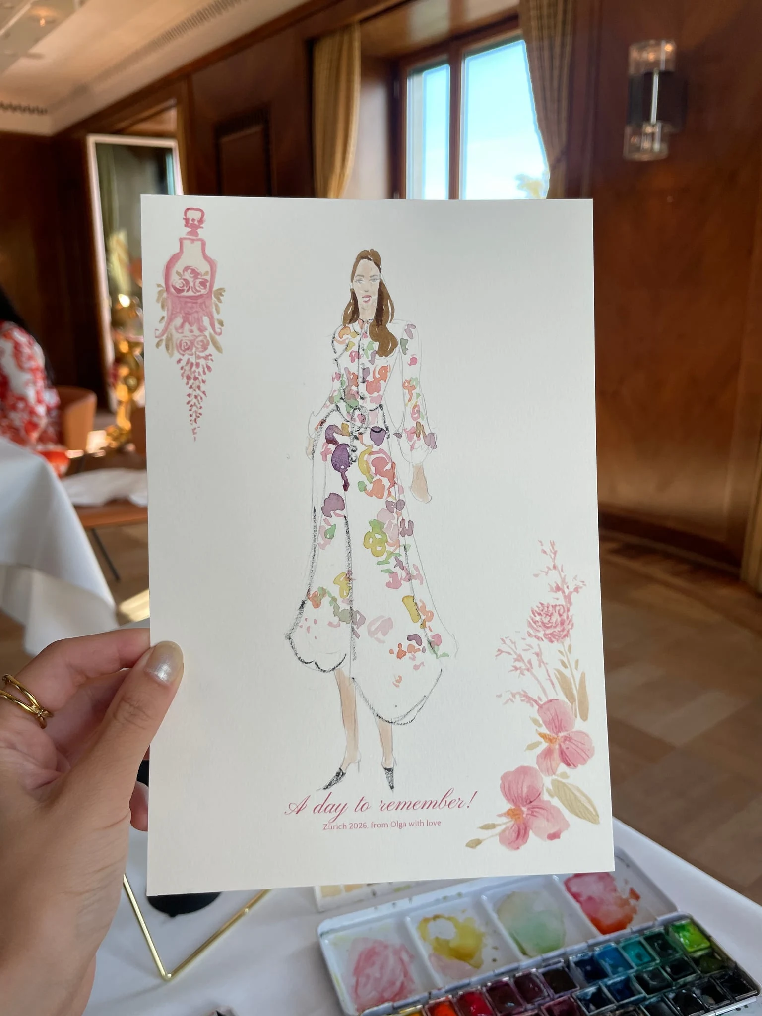 Live watercolor illustration of a guest in a white dress with colourful flowers at a birthday party at AMERON Zürich Bellerive au Lac.