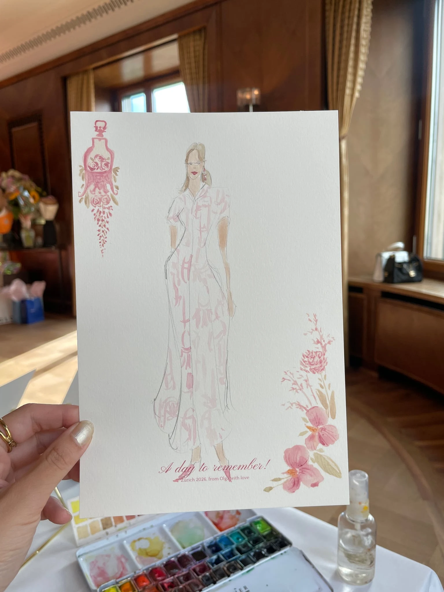 Live watercolor illustration of a guest in a white dress with a pink pattern at a birthday party at AMERON Zürich Bellerive au Lac.