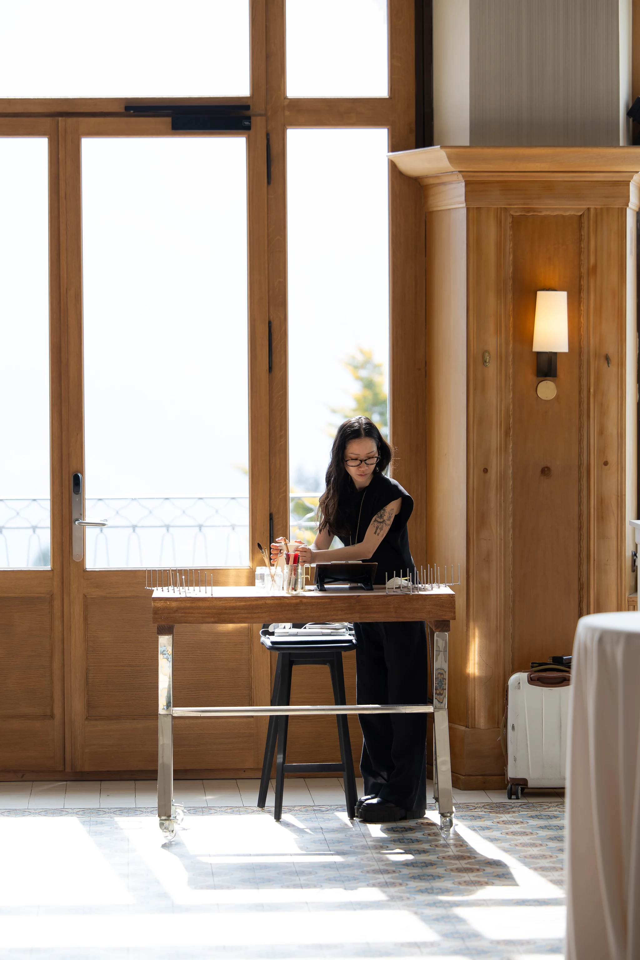 Linh preparing her painting station in the ballroom of Villars Palace before a wedding. © LeighAnn