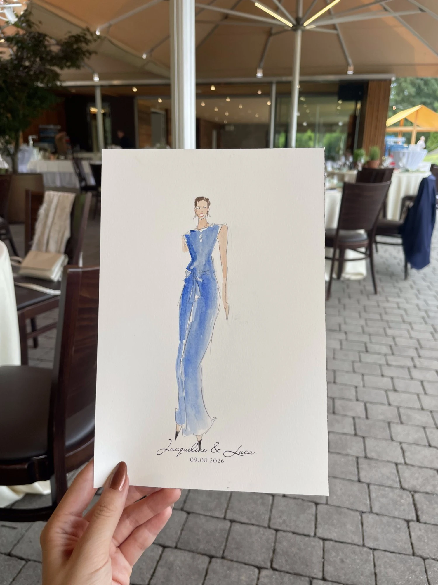 Live watercolor portrait of a wedding guest in a blue jumpsuit.