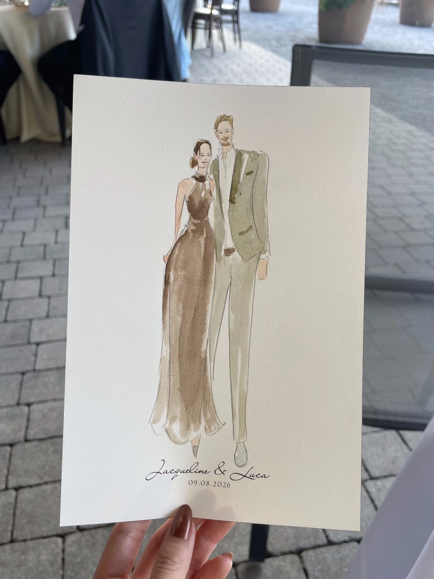 Live watercolor portrait of a guest couple: a brown halter gown and a sage suit.