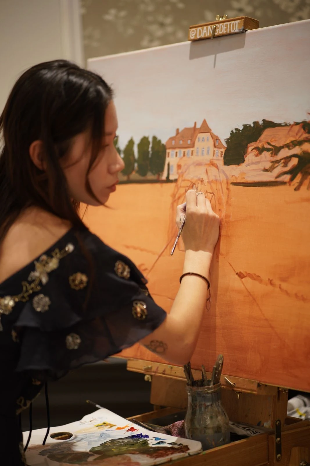 Close-up of the live wedding painter adding details to the château on the canvas. Photography by @pichou_.