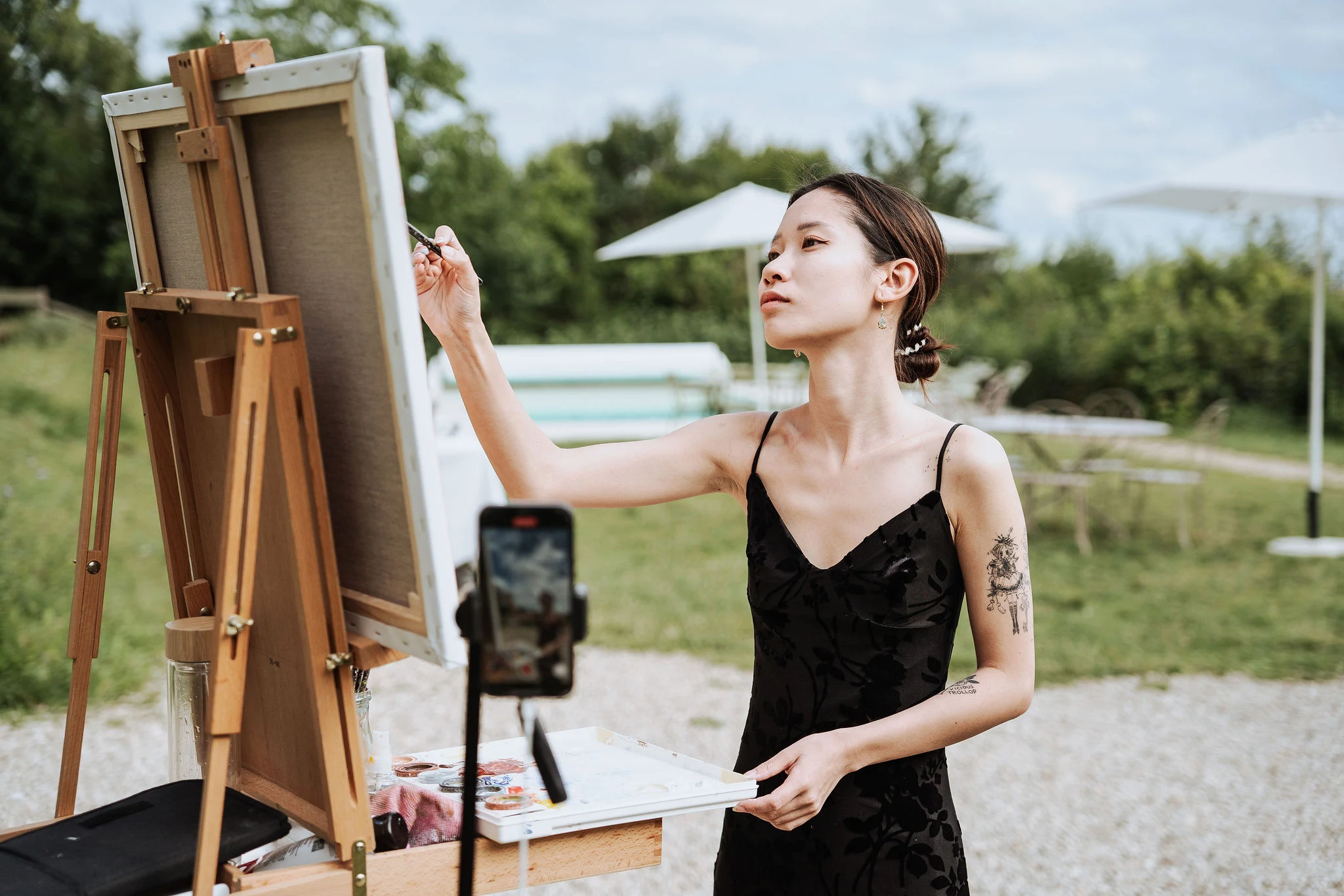 Close-up shot of artist Linh Dang (Dang de toi) painting details of a wedding scene. Photography by Kimmak Design.