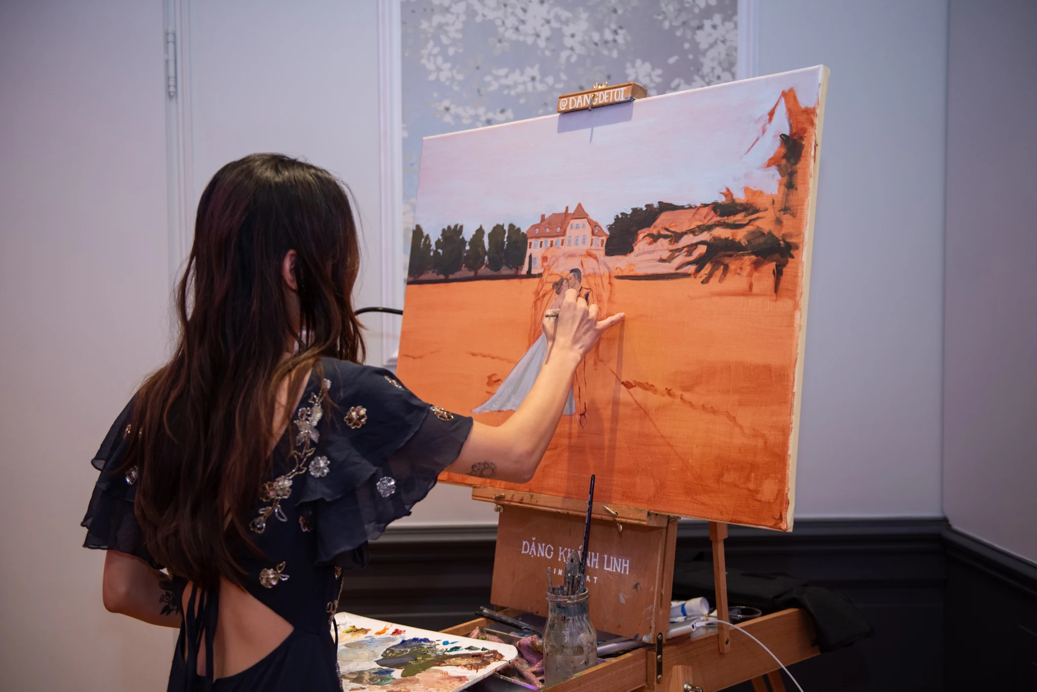 Live wedding painter painting the bride and groom on a canvas during the wedding at Château de la Tour. Photography by GC Photographie.