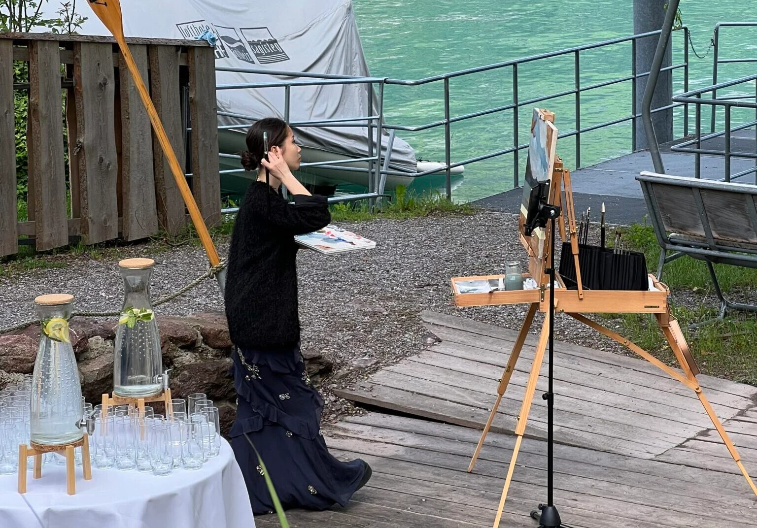 Live wedding painter in action at Lake Walenstadt Switzerland with mountain view.