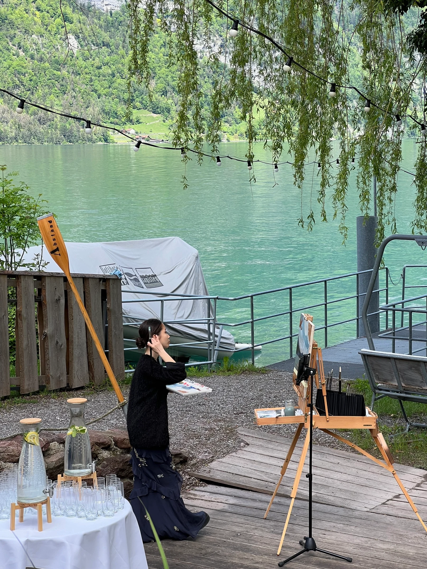 Live wedding painter in action at Lake Walenstadt Switzerland with mountain view.
