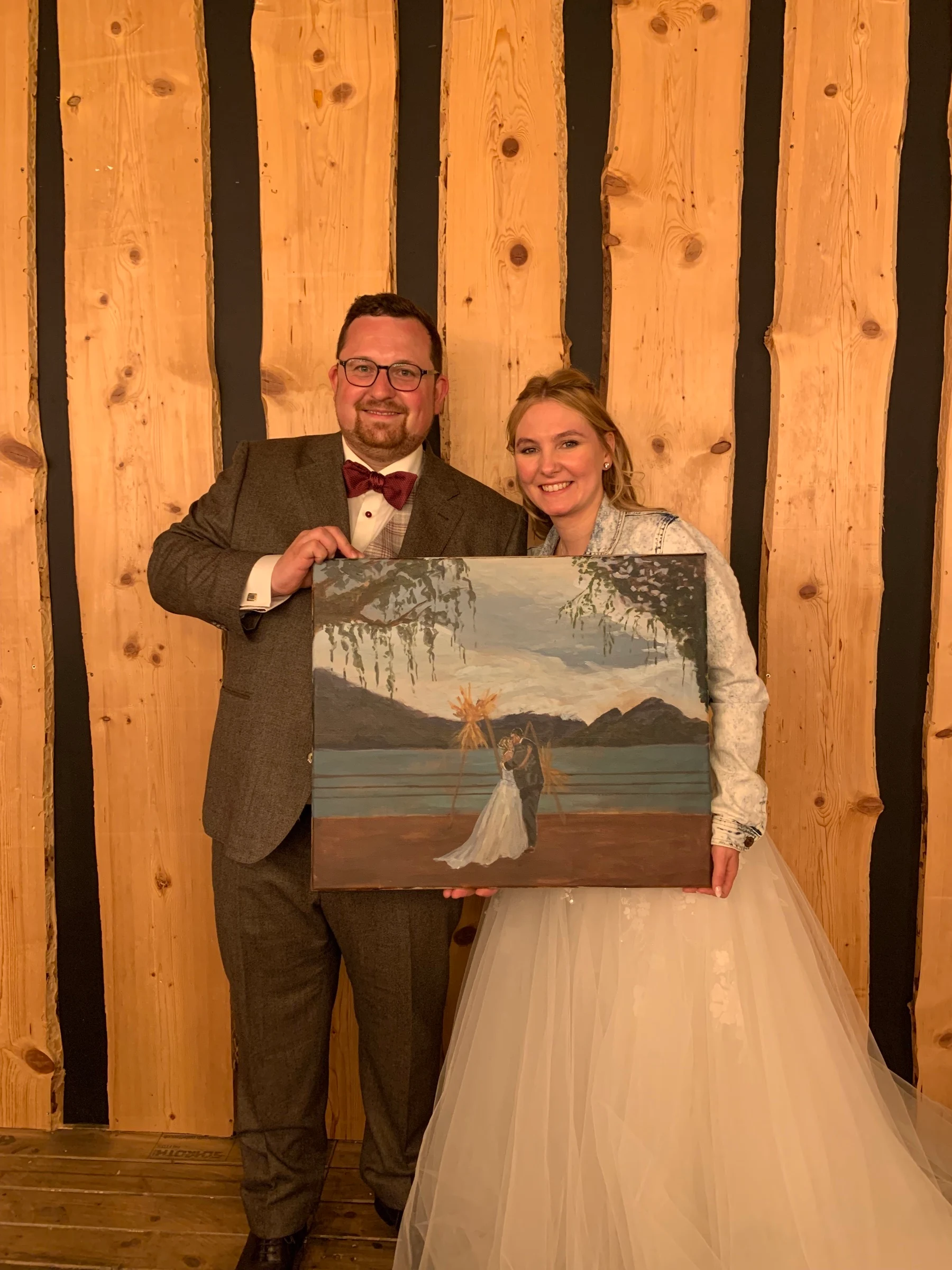 Newlyweds holding their live painting surprise gift at Sagibeiz.