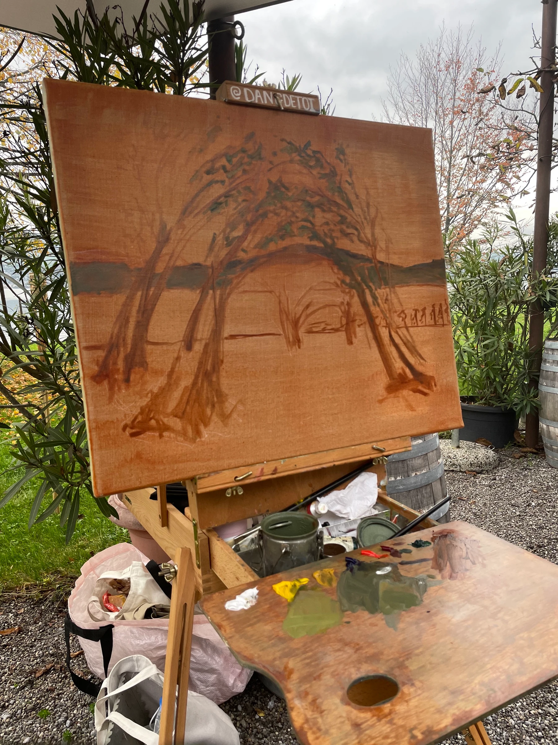 Step 1 of a live wedding painting: sketch of the tree dome and Lake Zurich on an orange canvas