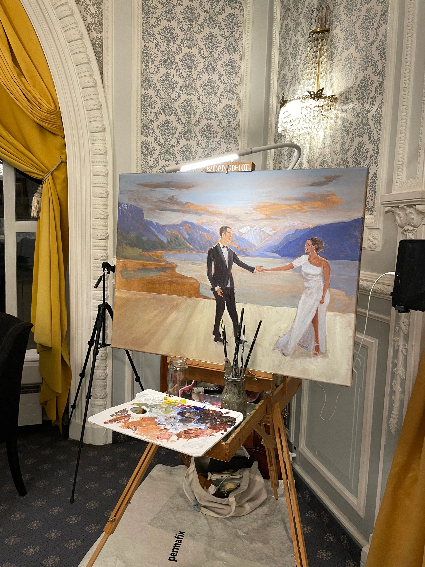 Live wedding painting at the end of the night on its easel in a salon at Le Mirador: a couple dancing with the Alps and Lake Geneva at sunset behind them.