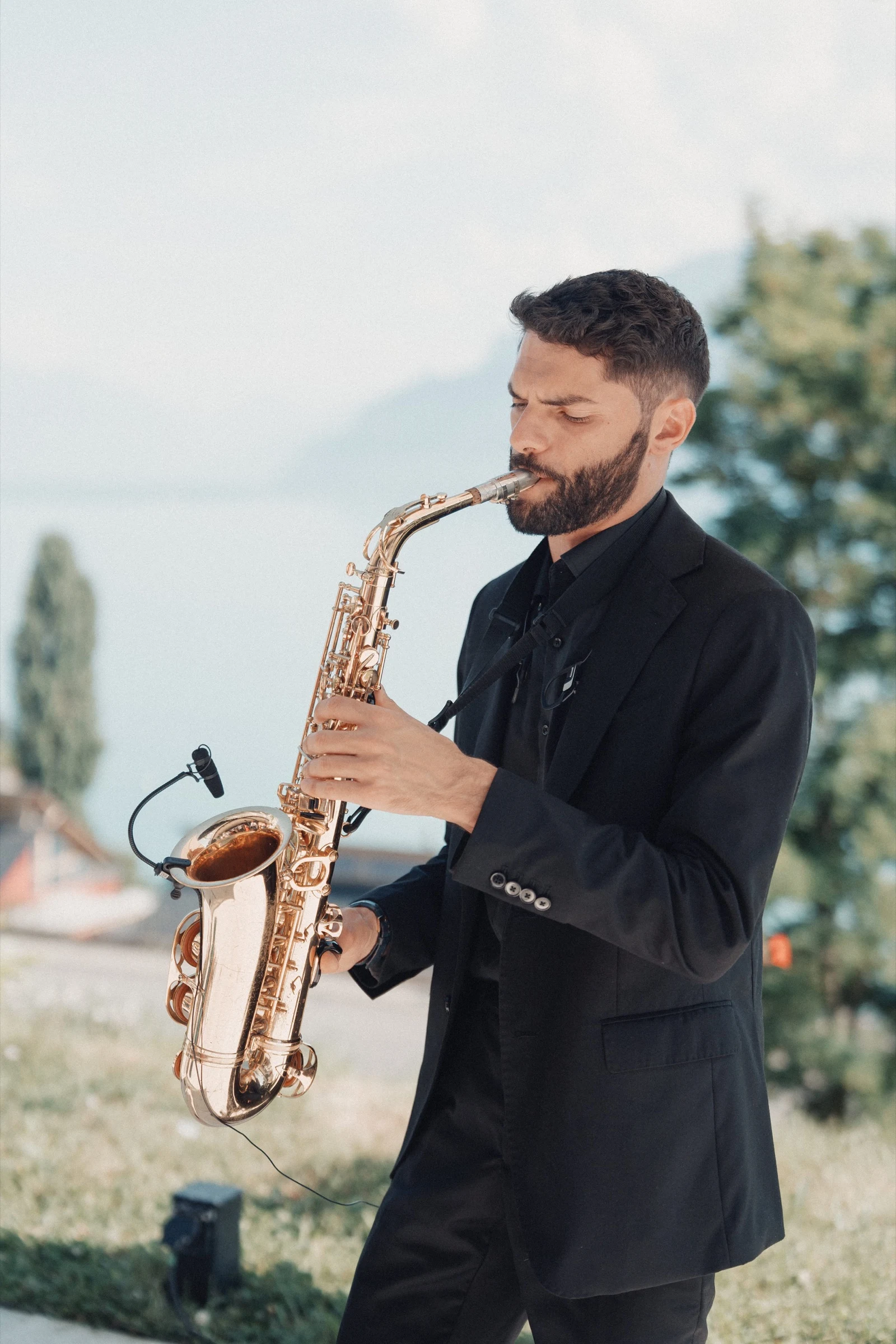Saxophonist playing during the cocktail hour on the terrace of Hôtel Préalpina above Lake Geneva.