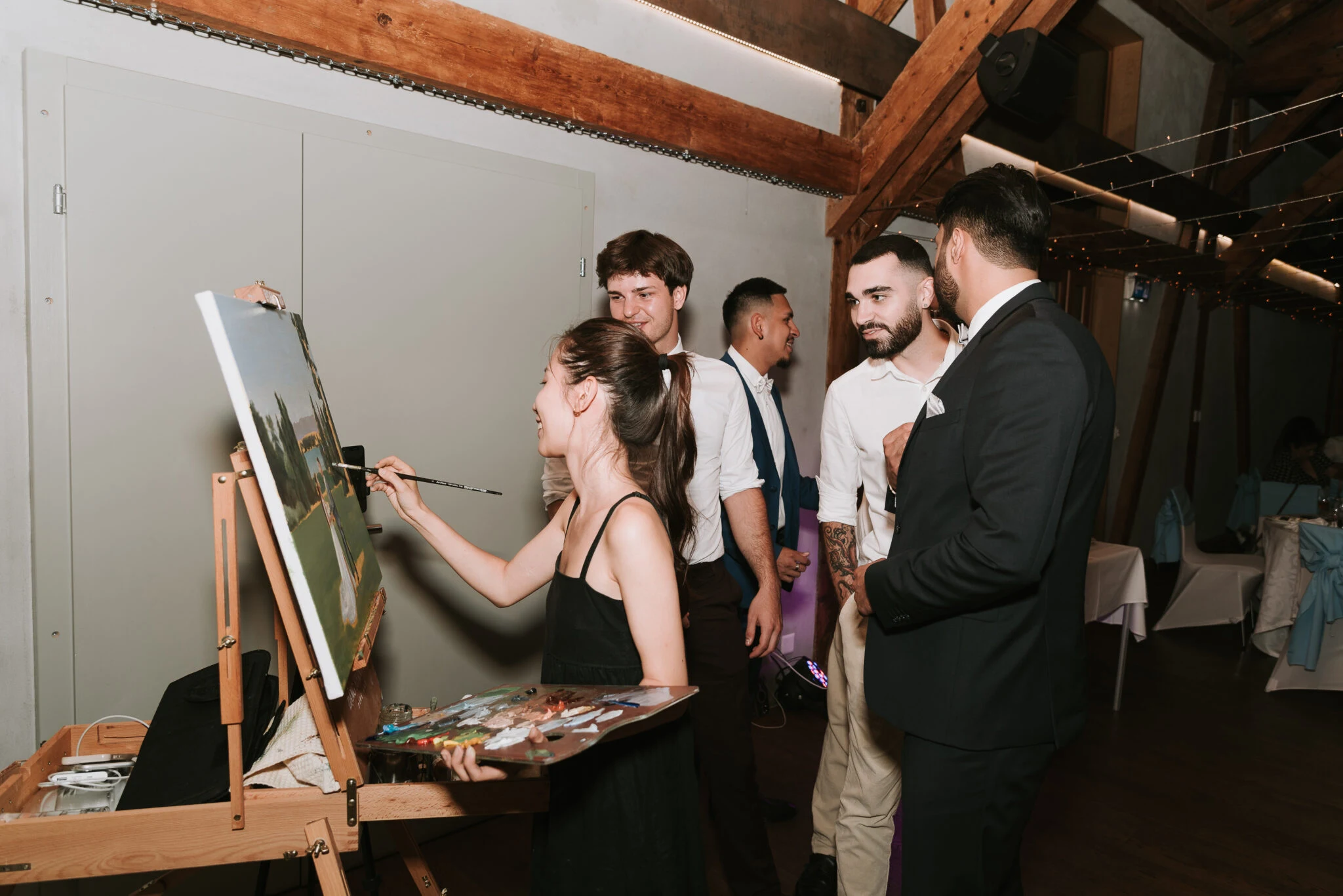 Wedding guests gathering around the live painting at Ferme du Lignon, Geneva