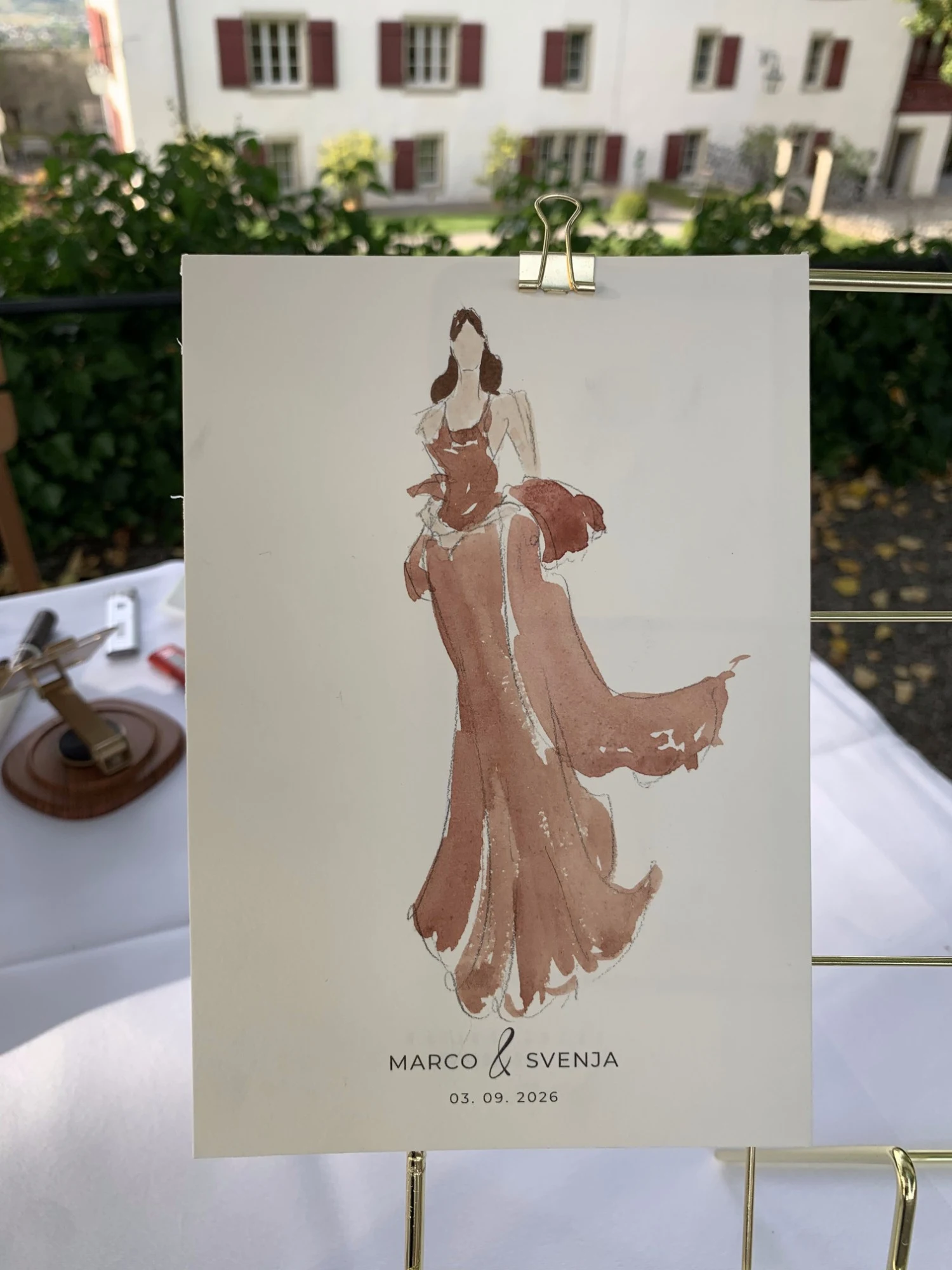 Live watercolor fashion sketch of a guest in a flowing terracotta gown at Schloss Lenzburg.