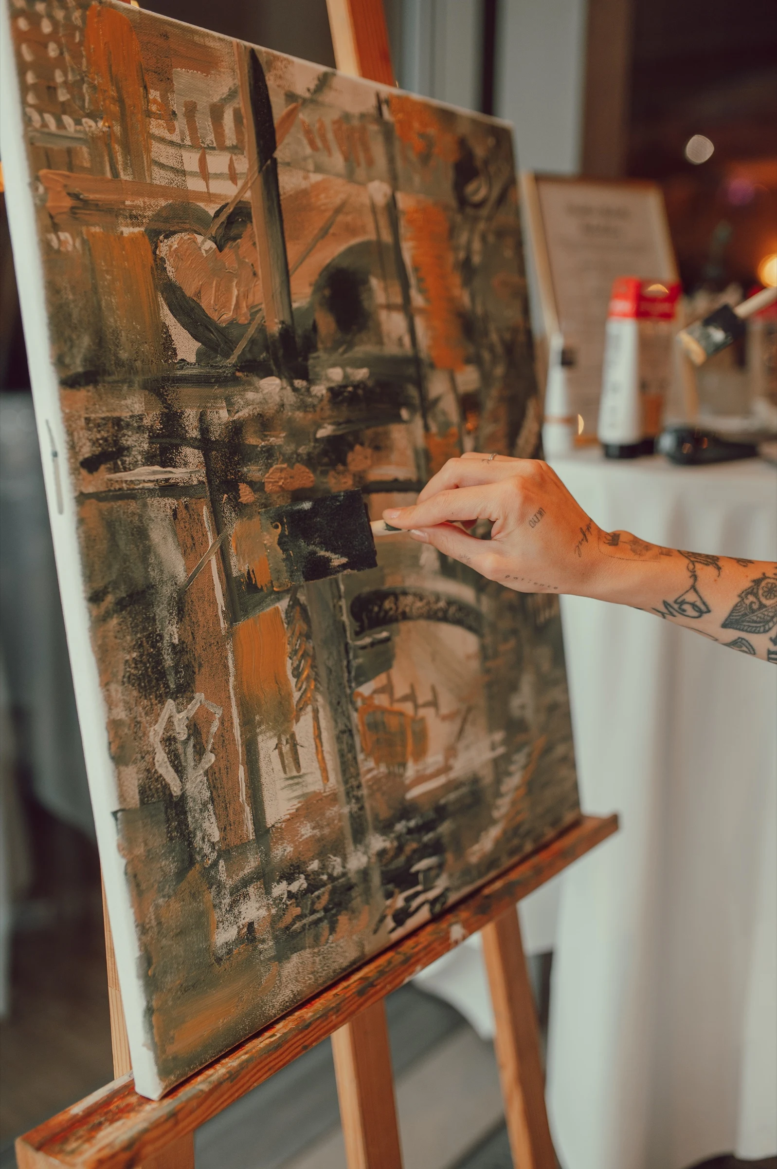 Close-up of the couple adding brushstrokes to the abstract guest painting at their wedding in Stäfa. Photography by Geraldine Rhyner Fotografie.