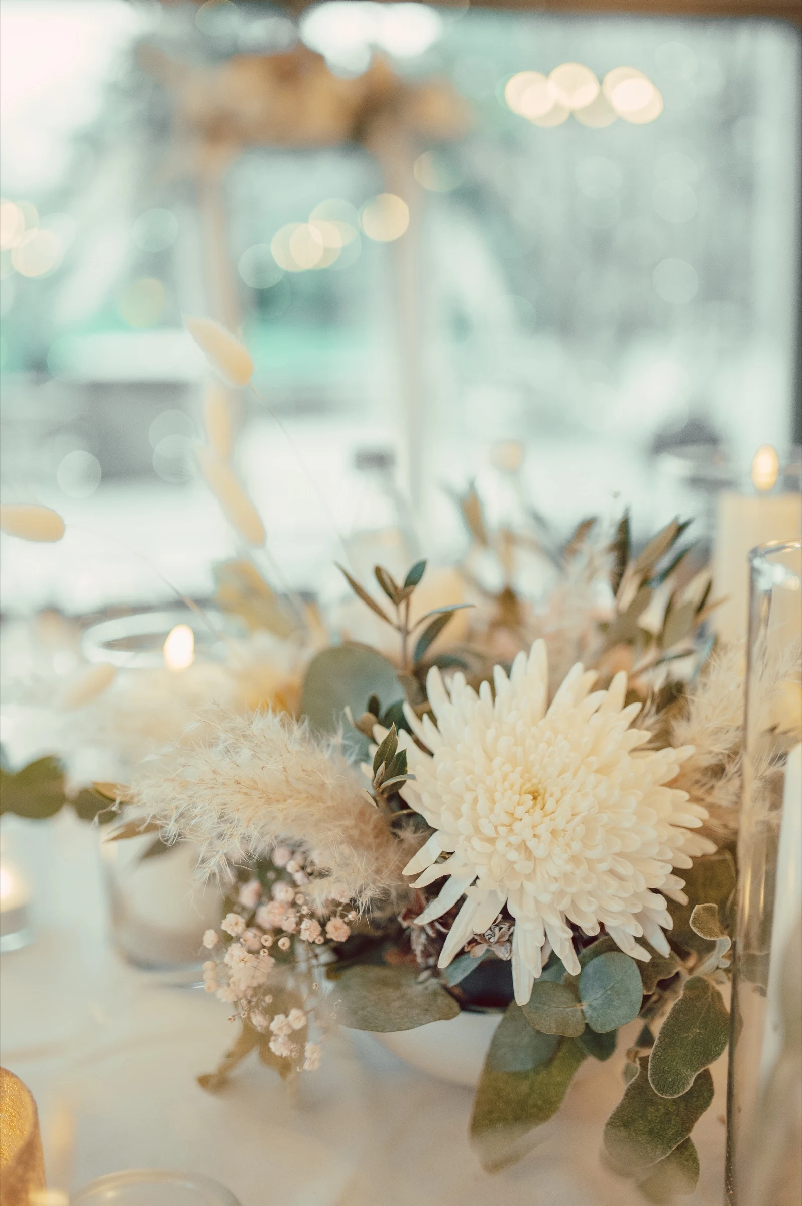 Wedding table centerpiece with a white chrysanthemum and pampas grass at Moschti Stäfa. Photography by Geraldine Rhyner Fotografie.